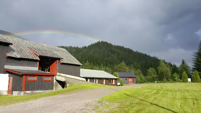 The farm building under a rainbow